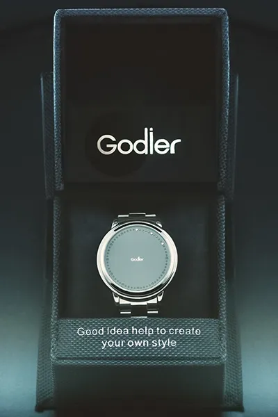 Luxuriöse Produktinszenierung: Godier Smartwatch in Box. Beispiel für hochwertige Werbefotografie für Markenpräsenz. Elegante Godier Smartwatch in schwarzer Präsentationsbox mit Logo und Slogan "Good Idea help to create your own style". Stilvolle Produktfotografie von Michael Schalansky